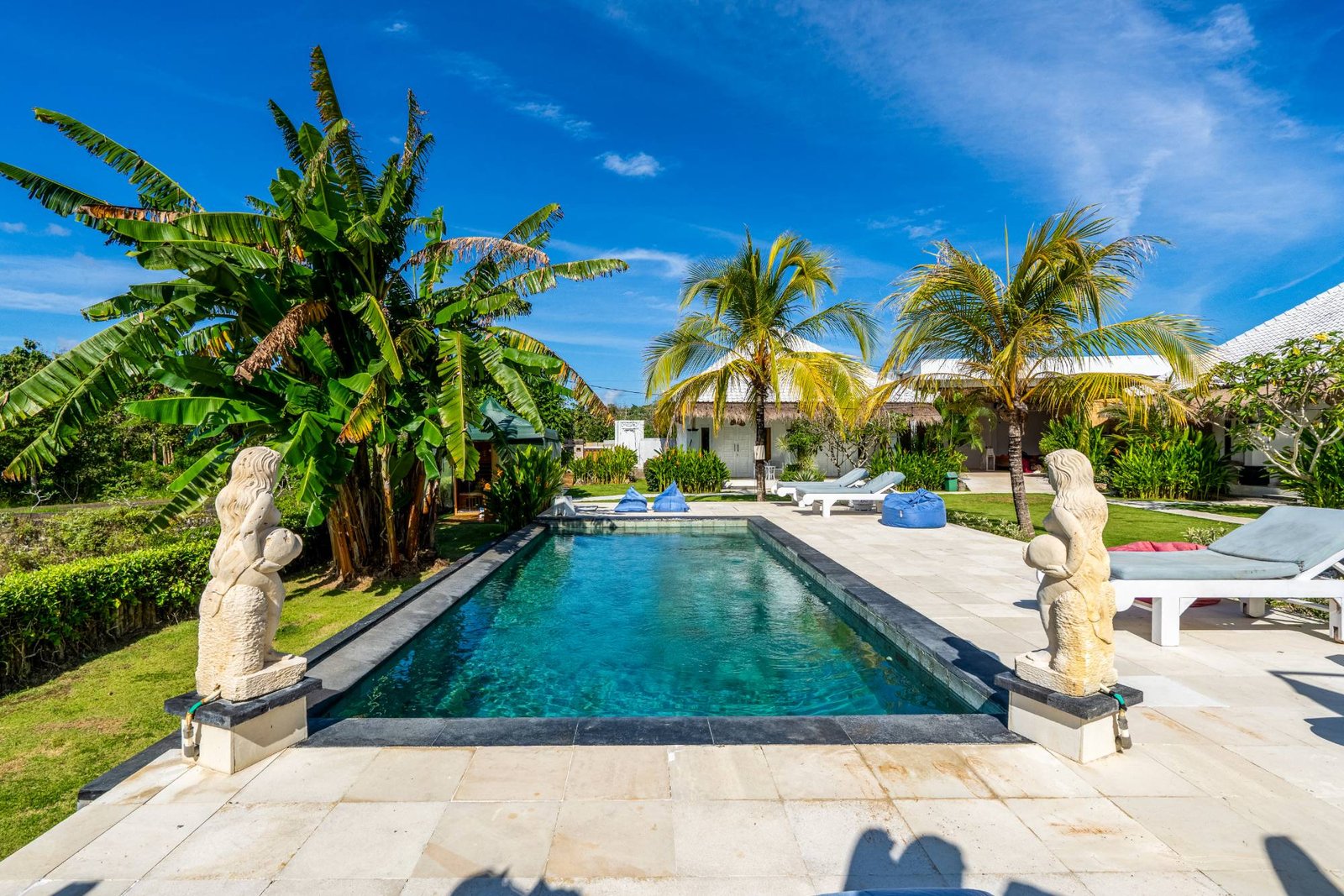 Infinity pool with Balinese statues and palms